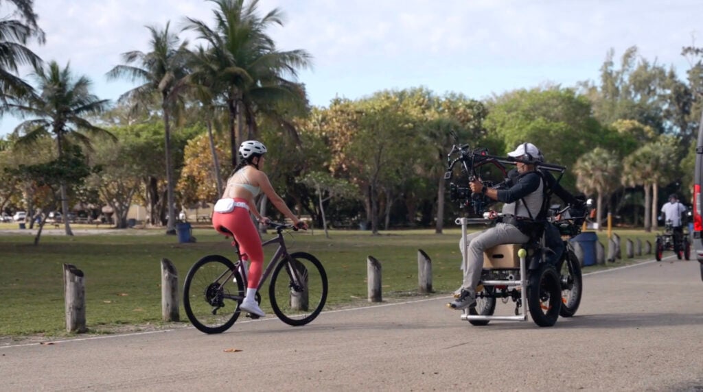 CSP Media Group's behind-the-scenes video of Peloton's scenic content showing Camila being filmed by crew on bike.